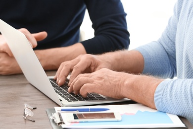 Mature manager consulting with man in office