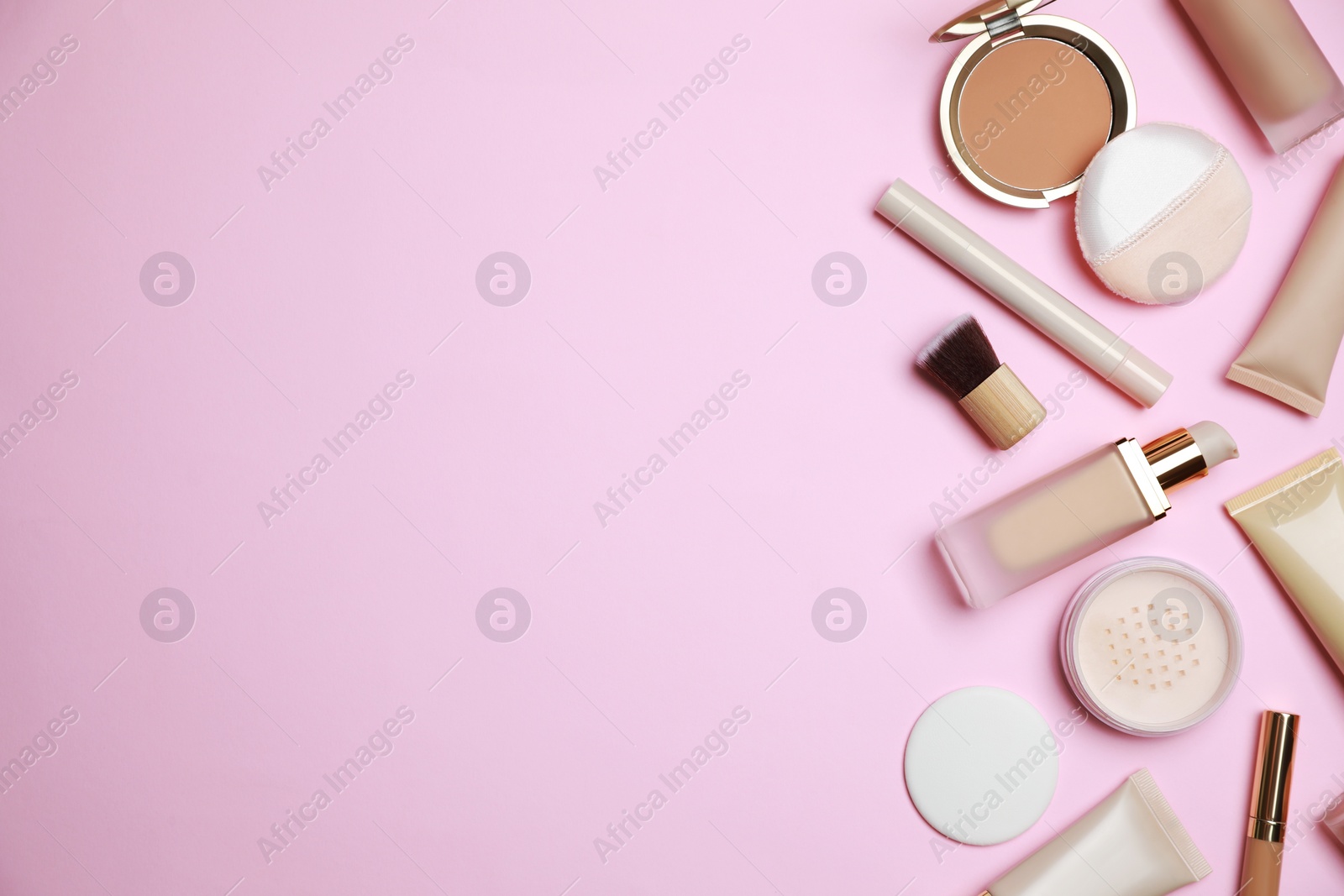 Photo of Face powders and other decorative cosmetic products on pink background, flat lay. Space for text