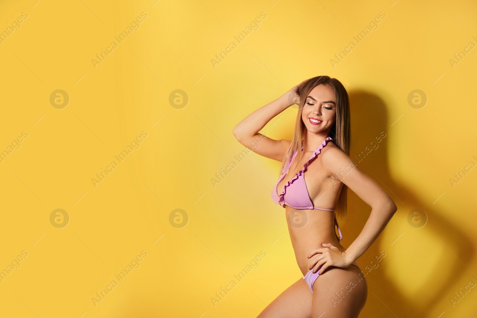 Photo of Pretty sexy woman with slim body in stylish bikini on color background, space for text
