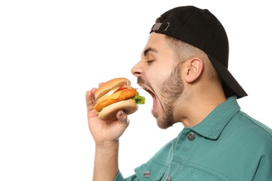 Handsome man eating tasty burger isolated on white