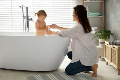 Photo of Mother with her little daughter in bathroom