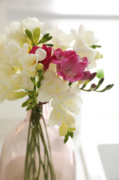 Beautiful bouquet of freesia flowers on countertop indoors, closeup