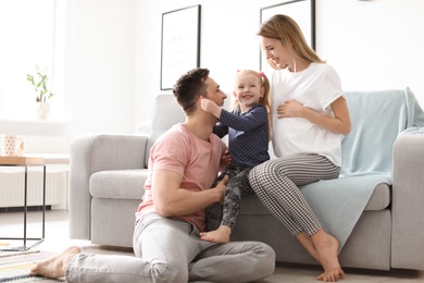 Young pregnant woman with her family at home