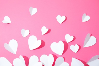 Small paper hearts on color background, top view