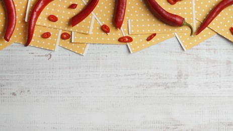 Pepper plasters and chili on white wooden table, flat lay. Space for text