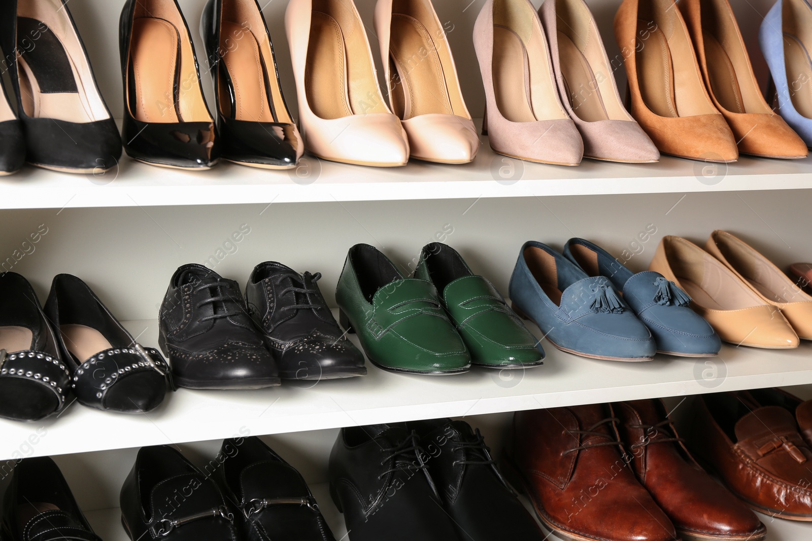 Photo of White shelving unit with different leather shoes