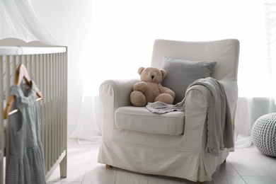 Baby room interior with comfortable crib and armchair