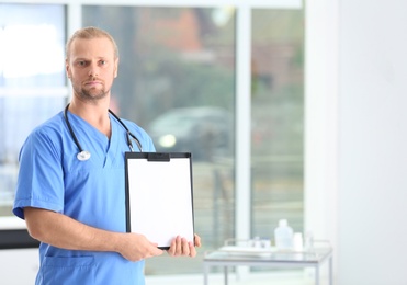 Photo of Portrait of medical assistant with stethoscope and clipboard in hospital. Space for text