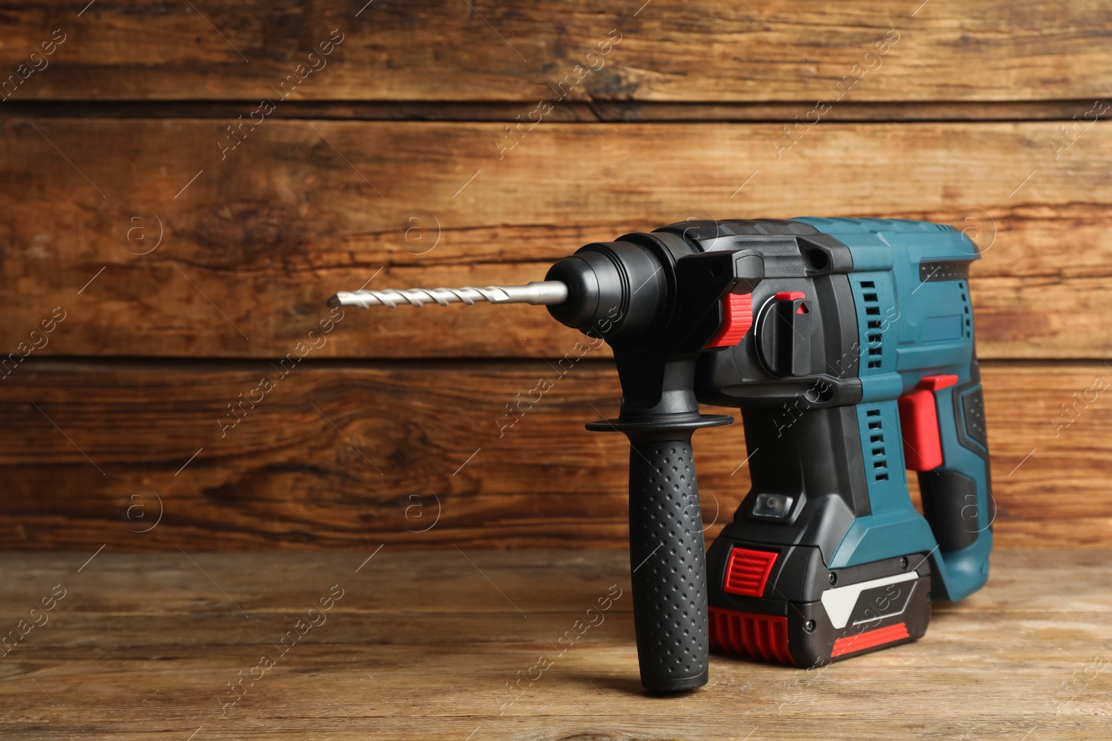 Photo of Modern electric power drill on wooden table, space for text