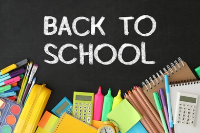 Image of Text Back To School and different stationery on black chalkboard, flat lay