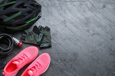 Photo of Flat lay composition with different cycling accessories on grey background, space for text