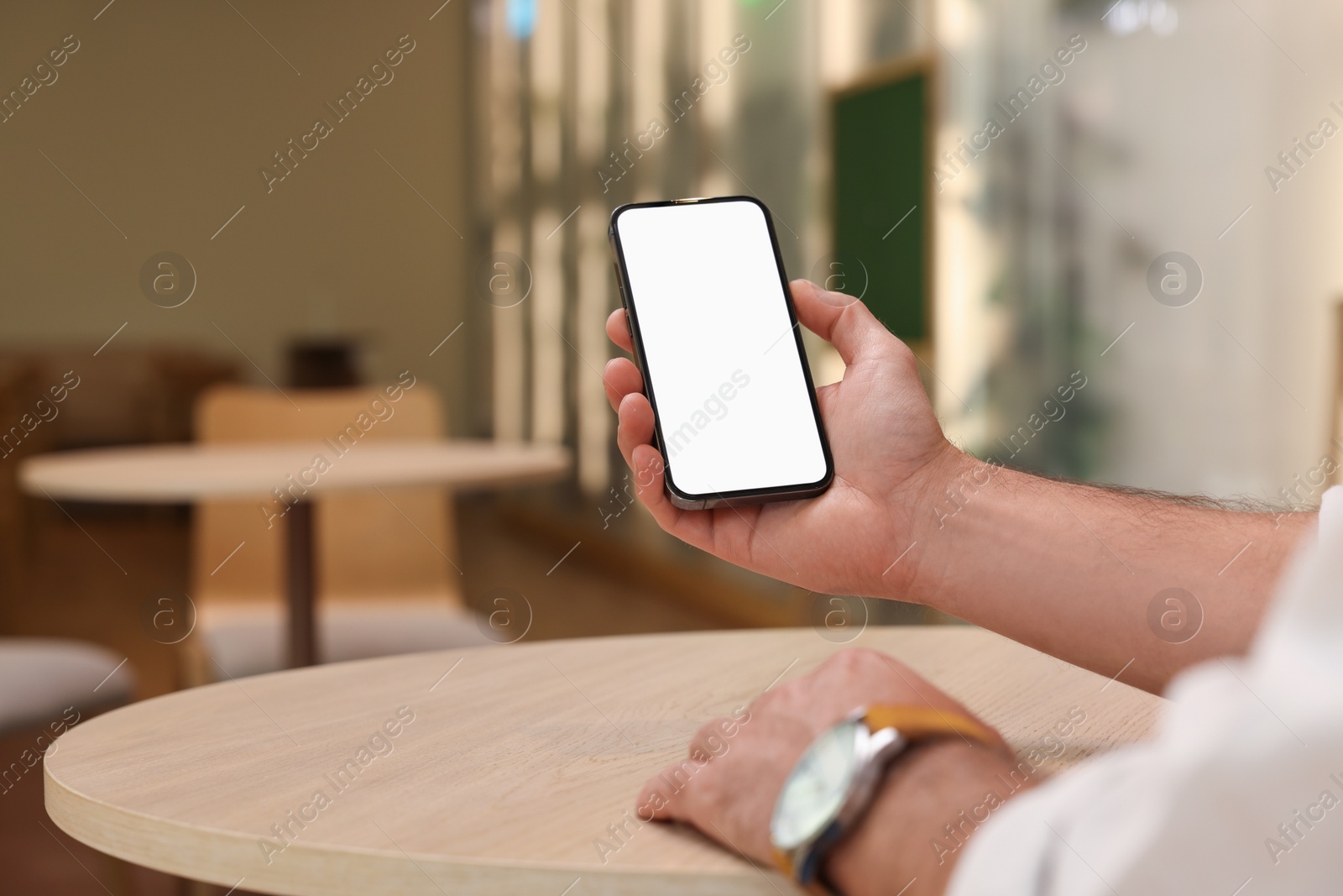 Photo of Man using smartphone at table in cafe, closeup