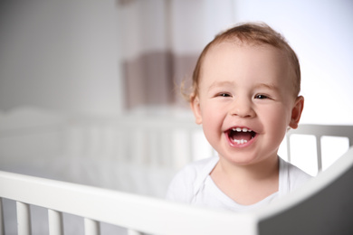 Cute baby in crib at home, space for text. Bedtime schedule