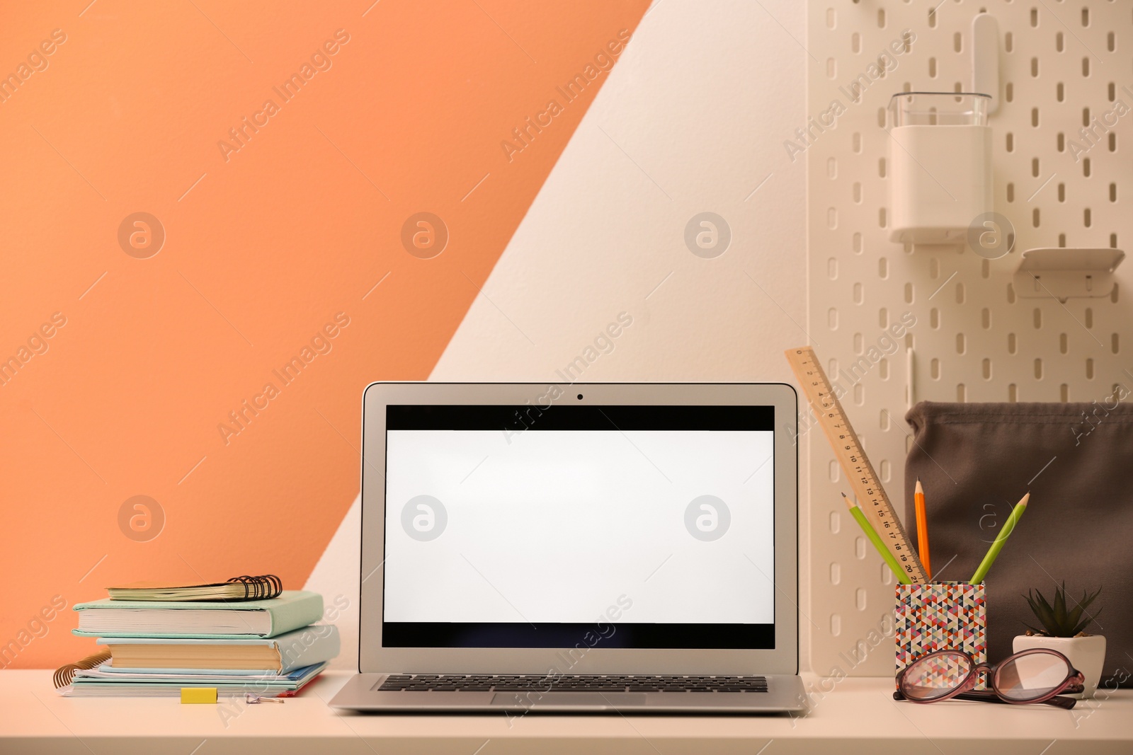 Photo of Modern laptop and stationery on table in office