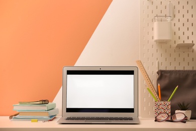 Photo of Modern laptop and stationery on table in office