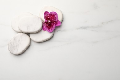 Photo of Flat lay composition with spa stones and orchid on white marble table. Space for text