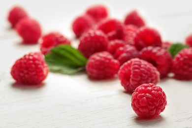 Ripe aromatic raspberries on wooden table