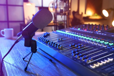 Microphone and professional mixing console on table in radio studio