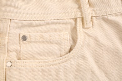 Beige jeans with inset pocket as background, closeup