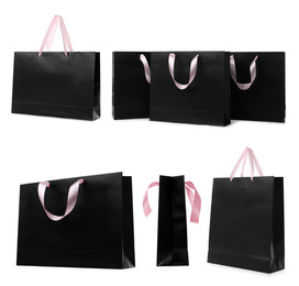 Image of Set with black paper shopping bags on white background