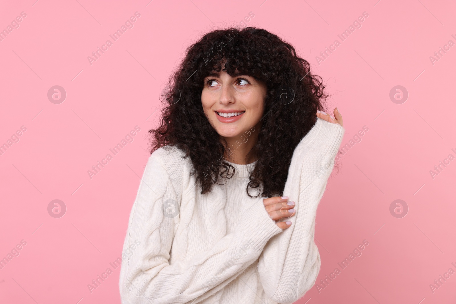 Photo of Happy young woman in stylish white sweater on pink background