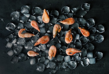 Photo of Flat lay composition with shrimps and ice cubes on dark background