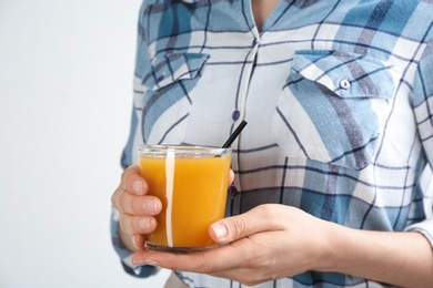 Photo of Woman with natural peach juice on light background, closeup