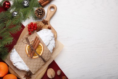 Traditional Christmas Stollen with icing sugar on white wooden table, flat lay. Space for text