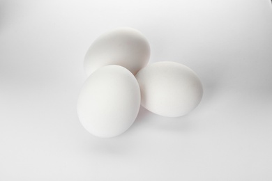 Photo of Few raw chicken eggs on white background