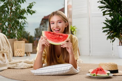 Beautiful teenage girl with slice of watermelon at home