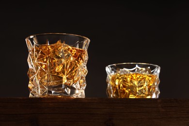 Whiskey in glasses on wooden table, low angle view