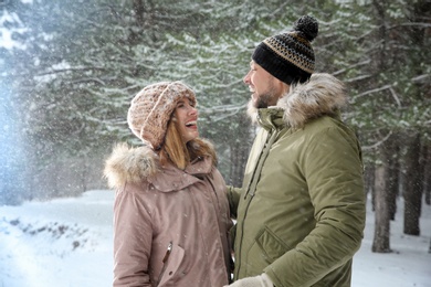 Happy laughing couple in forest on snow day