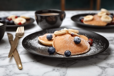 Tasty pancakes with banana and berries on plate