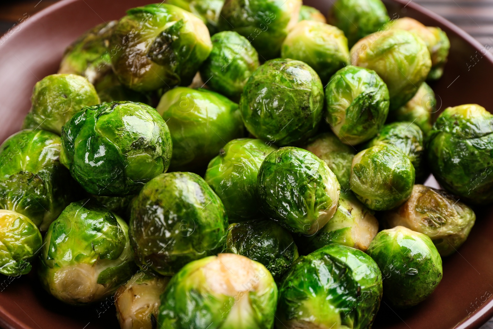 Photo of Delicious roasted Brussels sprouts on plate, closeup