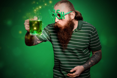 Man with beer on green background. St. Patrick's Day celebration