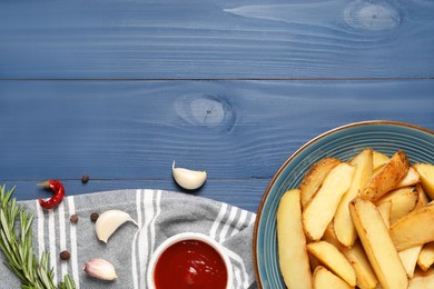 Photo of Flat lay composition with delicious baked potatoes, tomato sauce and rosemary on blue wooden table. Space for text