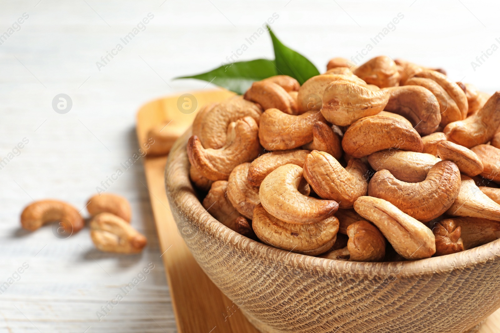 Photo of Bowl with cashew nuts on table, closeup