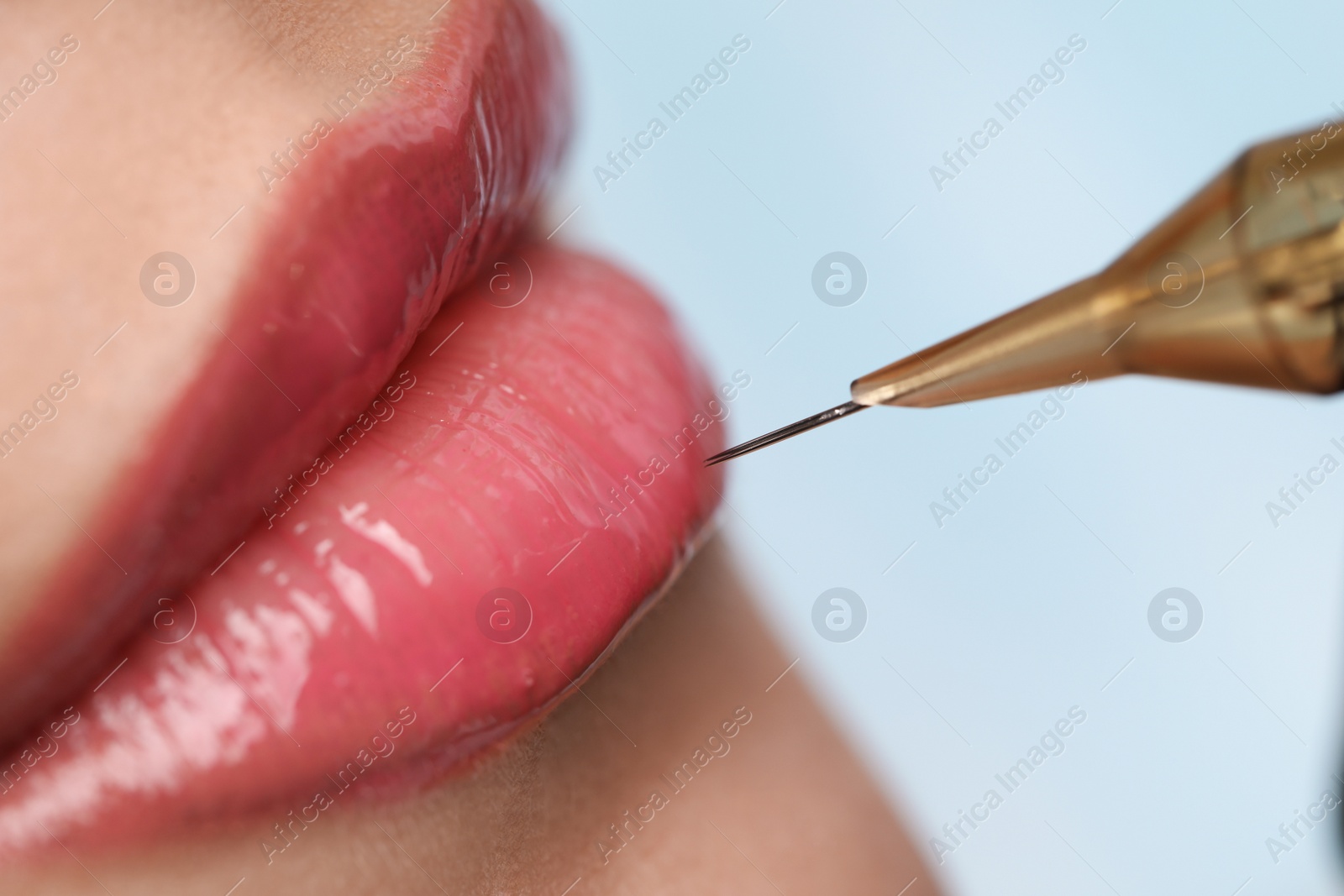 Photo of Young woman during procedure of permanent lip makeup in beauty salon, closeup