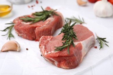 Photo of Fresh raw meat with rosemary on white table, closeup