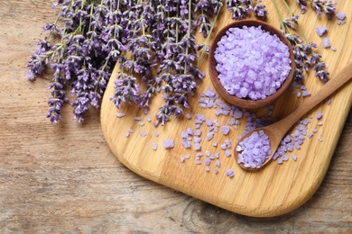 Flat lay composition with natural lavender bath salt and flowers on wooden table. Cosmetic product