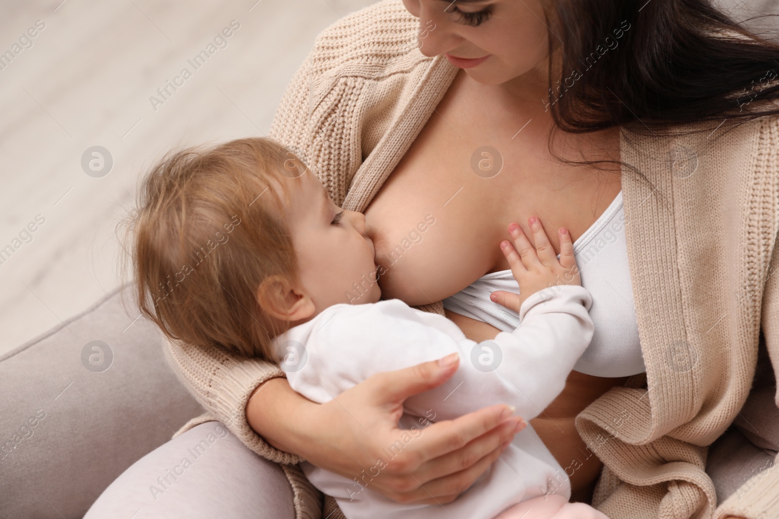 Photo of Woman breastfeeding her little baby at home