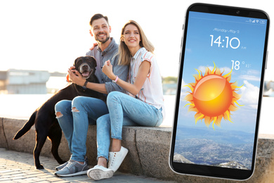 Happy couple near river and smartphone with open weather forecast app 