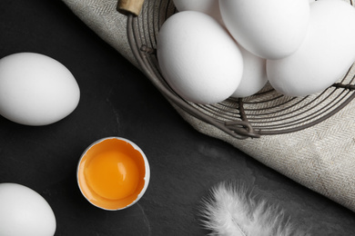 Photo of Flat lay composition with raw chicken eggs on black table