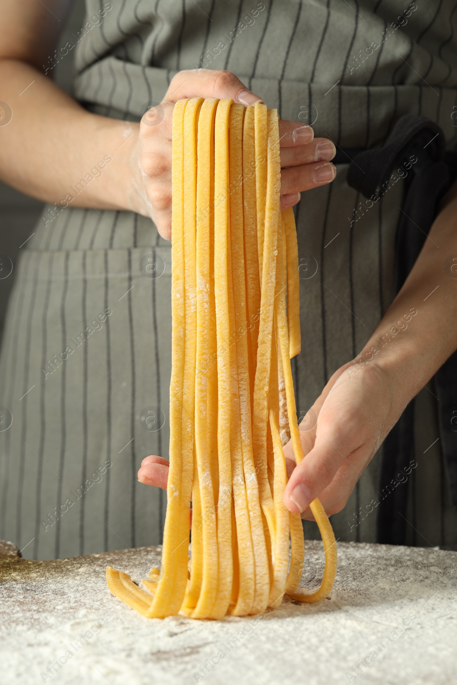 Photo of Woman making homemade pasta at table, closeup