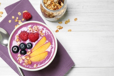 Photo of Delicious acai smoothie served on white wooden table, flat lay. Space for text