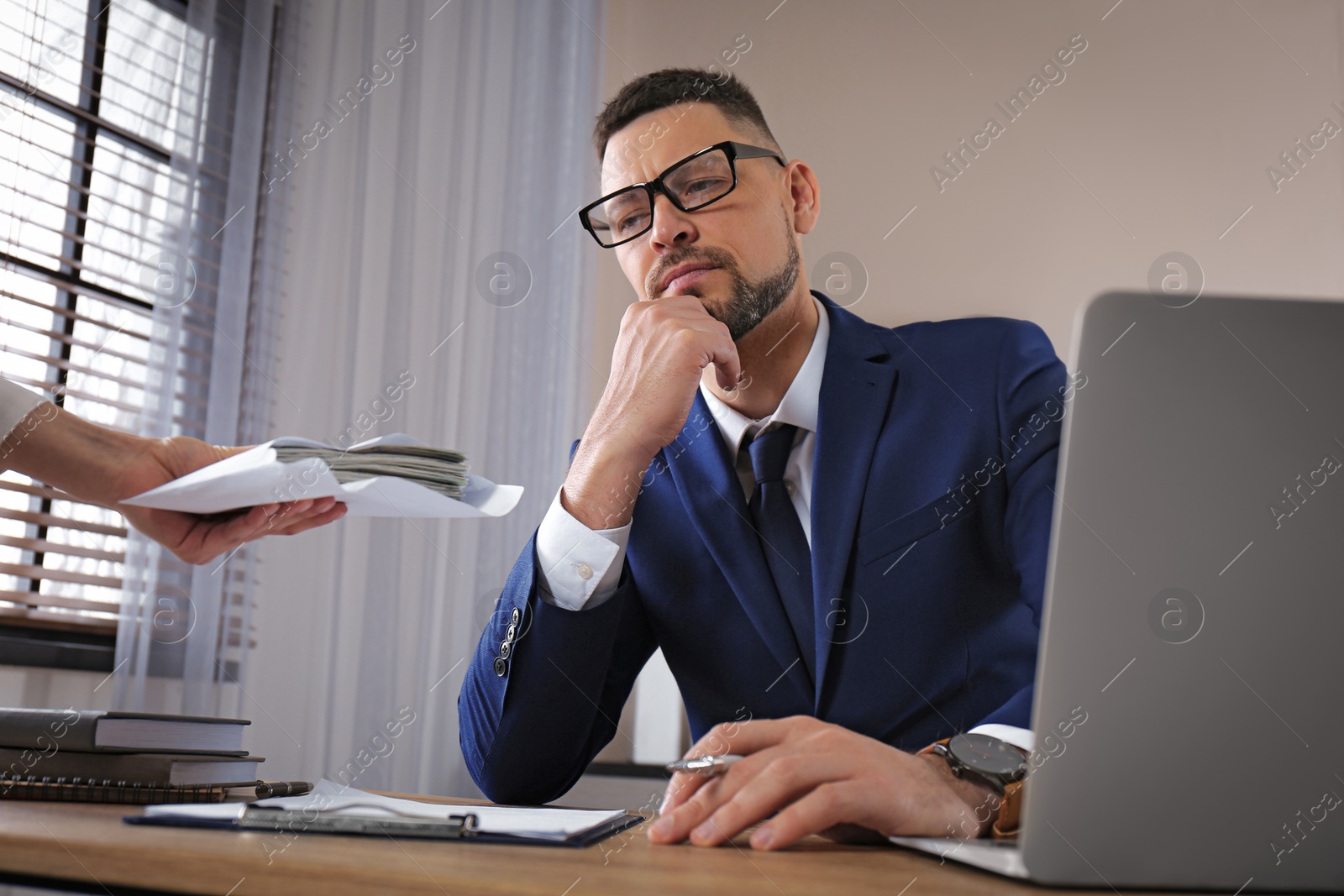 Photo of Woman offering bribe to man at table in office