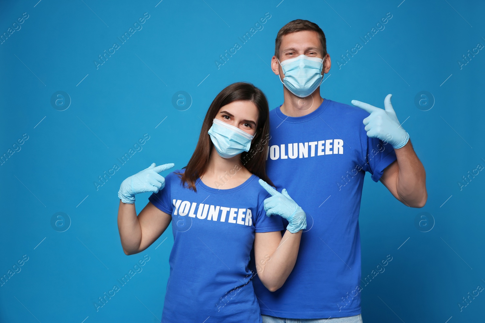 Photo of Volunteers in masks and gloves on blue background. Protective measures during coronavirus quarantine