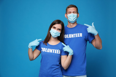 Photo of Volunteers in masks and gloves on blue background. Protective measures during coronavirus quarantine