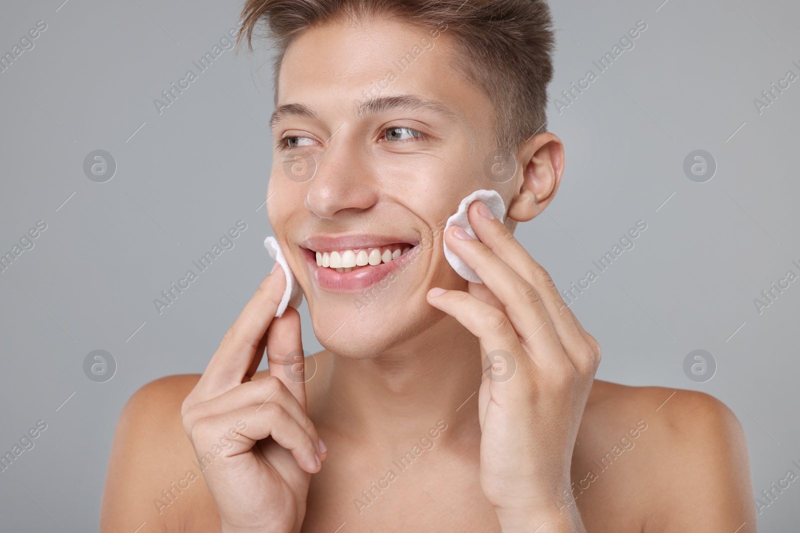 Photo of Handsome man with cotton pads on grey background