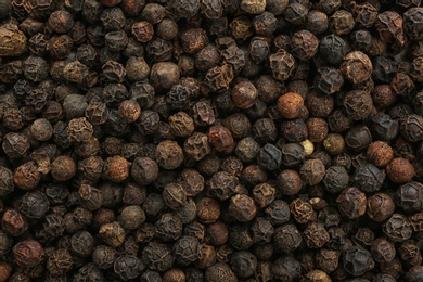 Photo of Black pepper corns as background. Natural spice